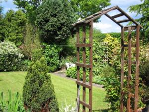eine Holzleiter mitten in einem Garten in der Unterkunft Charming Lilac Cottage, Aldbrough, East Yorkshire in Aldbrough