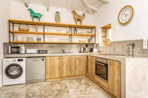 a kitchen with a washing machine and a clock on the wall at Villa Dassos by Villa Plus in Skinária