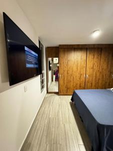 a bedroom with a large flat screen tv on the wall at Moderno apartamento con balcon y vista al guadual, Piscina y parqueadero in Pereira