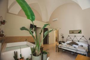 ein Schlafzimmer mit einem Bett und einer Topfpflanze in der Unterkunft 4 Balconi rooms-Boutique B&B in Lecce
