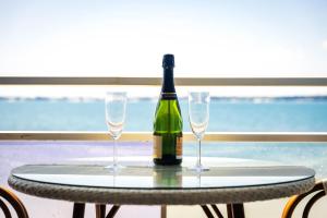 a bottle of wine sitting on a table with two glasses at Valinor - Charming studio - Concarneau beach - Close to spa in Concarneau