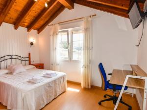 ein Schlafzimmer mit Bett, Schreibtisch und Fenster in der Unterkunft Preciosa casa con vistas al mar in Santander