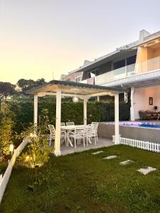 ein Pavillon mit Tisch und Stühlen in einem Hof in der Unterkunft Crystal Pool Villa Bay of Lalzi in Draç