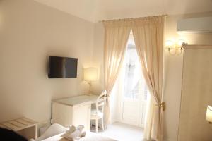 a bedroom with a desk and a window with a television at La Torre in Catania +29 photos
