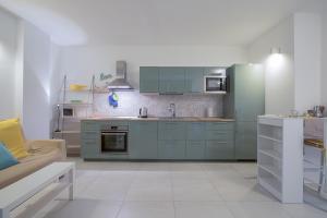 - une cuisine avec des placards bleus et un canapé dans l'établissement Stay Smart Pisa - parcheggio privato, à Pise