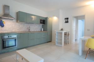 une cuisine avec des armoires bleues et une table et des chaises dans l'établissement Stay Smart Pisa - parcheggio privato, à Pise 26 autres photos