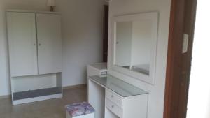 a kitchen with white cabinets and a mirror at Rooms Leonidas in Kissamos +135 photos