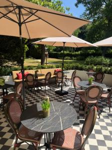 an outdoor patio with tables and chairs and umbrellas at Villa V - Petit Hôtel in Valkenburg