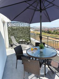 a patio with a table and chairs and an umbrella at APARTAMENT PANORAMIC in Alba Iulia