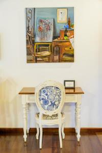 a table with a chair and a painting on the wall at Haras Buona Fortuna in Cotia
