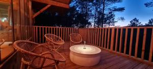 a porch with two chairs and a table and a fence at Le Masdemoiselle Chalet in Salernes