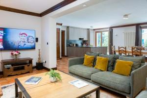 a living room with a couch and a table at Pothecary apartment -Chamonix All Year in Chamonix-Mont-Blanc