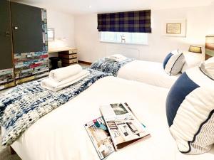 a hotel room with two beds and a tv at Bertie by The Suffolk Cottage Collection in Chillesford