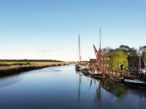 a group of boats are docked in a river at Bertie by The Suffolk Cottage Collection in Chillesford