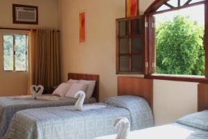 a bedroom with two beds with swans on them at Hotel Fazenda Tucano in Capim Branco +55 photos