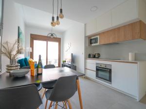 Una cocina con una mesa y sillas en una habitación. en YourSpain LM1B Apartament La Mata, en La Mata 3 fotos más