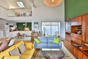 a living room with a blue couch and a kitchen at Brem sur mer - Maison familiale in Brem-Sur-Mer