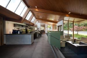 a lobby with a bar and some chairs and windows at Scenic Hotel Franz Josef Glacier in Franz Josef