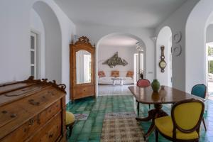 a room with a table and chairs and a bedroom at Il Carrubo Capri in Anacapri