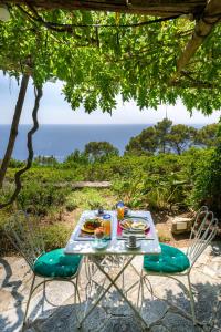 a table with food and a view of the ocean at Il Carrubo Capri in Anacapri