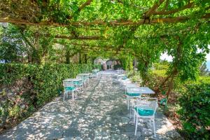 a row of tables and chairs under a pergola at Il Carrubo Capri in Anacapri