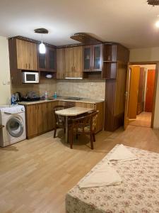 Una cocina con gabinetes de madera y una mesa en ella. en Апартамент генерал столетов, en Varna