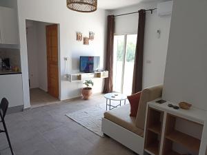 a living room with a couch and a tv at Le nid cosy in Tabarka