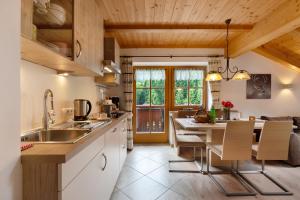 a kitchen with a sink and a table with chairs at Untertalhof in Castelrotto
