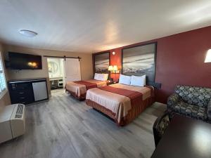 a hotel room with two beds and a flat screen tv at Motel 6 Pasadena, CA Old Town Pasadena Area in Pasadena