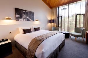 
a hotel room with a bed and a desk at Scenic Hotel Franz Josef Glacier in Franz Josef
