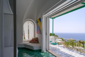 a room with a balcony with a view of the ocean at Il Carrubo Capri in Anacapri