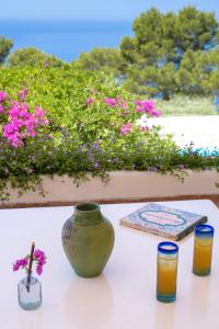a table with a vase and two glasses of orange juice at Il Carrubo Capri in Anacapri