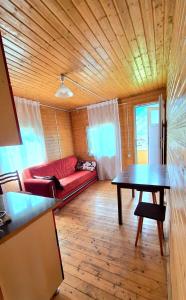 a living room with a red couch and a table at Cottage Keleri in Mazeri