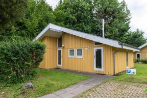 a yellow house with a sign in front of it at Seeschwalbe 242 in Mirow