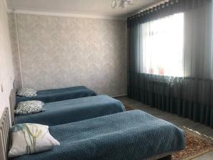 a room with three blue beds in a room with a window at GuestHouse "ERKIN" in Karakol