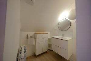 Proche Rouen - Magnifique T4 - 3 chambres في Déville-lès-Rouen: حمام أبيض مع حوض ومرآة