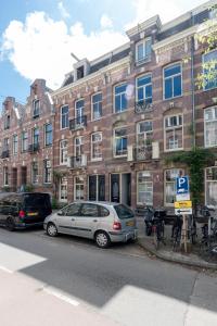 two cars parked in front of a brick building at Vondel 99 in Amsterdam