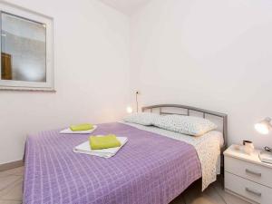 a bedroom with a purple bed with towels on it at Apartment in Vrbnik - Insel Krk 13615 in Vrbnik