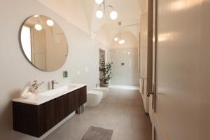 a bathroom with a sink and a toilet and a mirror at Le Stonghe City Apartment in Fossombrone