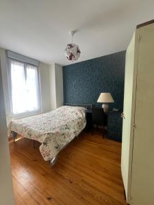 a bedroom with a bed and a lamp and a window at Maisoncat in Mézières-sur-Seine