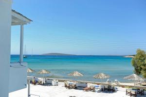 a beach with chairs and umbrellas and the ocean at Galatis Beach Hotel in Aliki