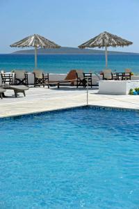 Galatis Beach Hotel في أليكي: مسبح مع كراسي ومظلات على الشاطئ