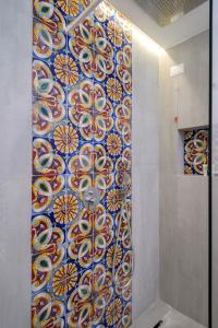 a shower with a colorful tile wall in a bathroom at Il Carrubo Capri in Anacapri