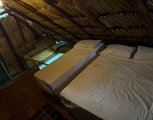 two beds in a room with a roof at El Refugio Natural in Turbaco