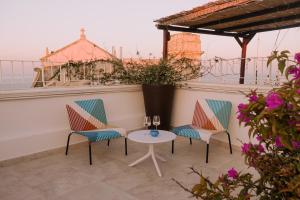 a patio with two chairs and a table with wine glasses at Innesto Rooms - Monopoli in Monopoli