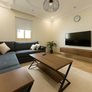 a living room with a couch and a flat screen tv at Stylish 3BR Smart TV & Wi-Fi in Jeddah
