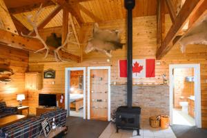 a living room with a fireplace in a log cabin at Sherbrooke Lake Cottage with Private Beach in Mahone Bay