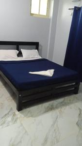 a bed with a blue mattress with a napkin on it at Calangute Pristine Guest House in Calangute