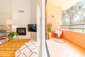 a living room with a couch and a tv at Apartment Aroeira Golf II in Carcereiro