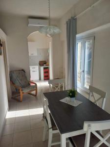 a dining table and chairs in a living room at Egidio's House Casa Vacanze Portixeddu in Portixeddu